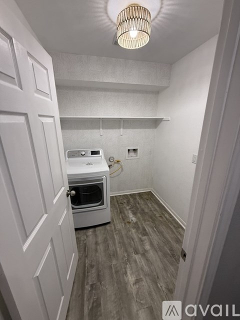 A kitchen with a white oven and wooden flooring.