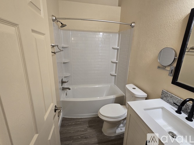 A bathroom with a white tub, toilet, and sink.