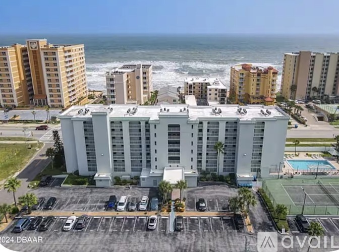 A hotel with a parking lot in front of it.