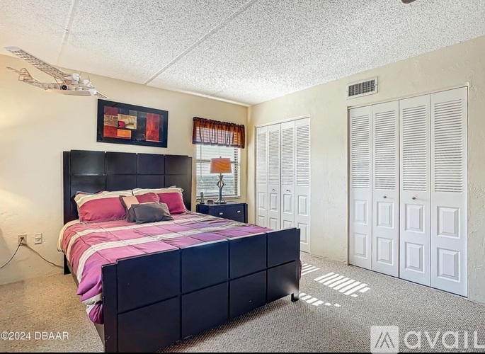 A bedroom with a large bed and a ceiling fan.