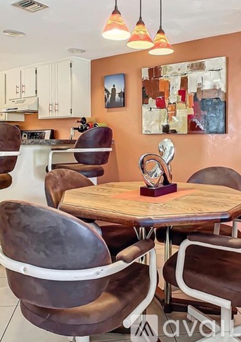 A dining room with brown chairs and a wooden table.