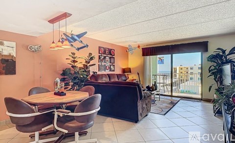 A living room with a brown leather couch and a wooden table.
