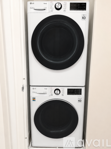 Two white LG front loading washing machines stacked on top of each other.