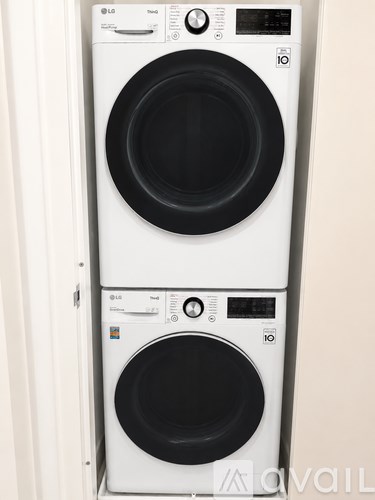 Two white LG front loading washing machines stacked on top of each other.