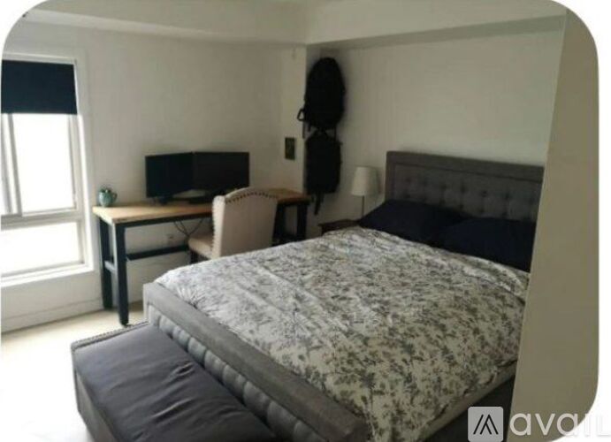 A bedroom with a bed, desk, and chair.
