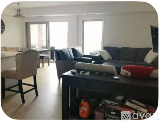 A living room with a grey couch, a white chair, and a black entertainment center.