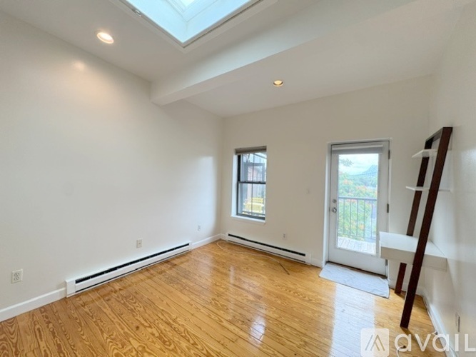 A room with wooden floors and a skylight.