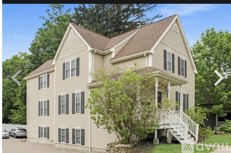 A two-story house with a beige exterior and a brown roof.