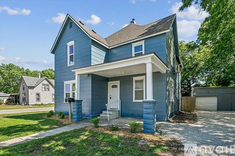 A blue house with a white door and windows.