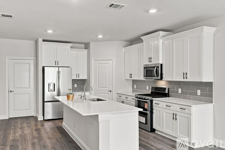 A modern kitchen with white cabinets and appliances.