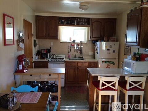 A kitchen with a table and chairs in front of a refrigerator.