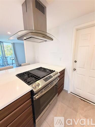 A modern kitchen with a stove top oven and range hood.