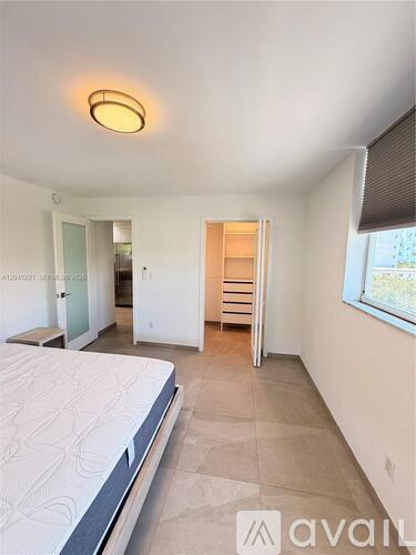 A bedroom with a bed, dresser, and window.