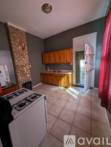 A kitchen with a white stove top oven and a brick chimney.