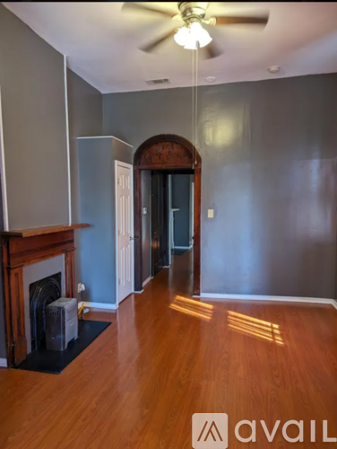A room with a fireplace and a ceiling fan.