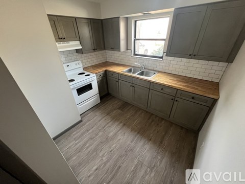 A kitchen with a white stove top oven and a window.