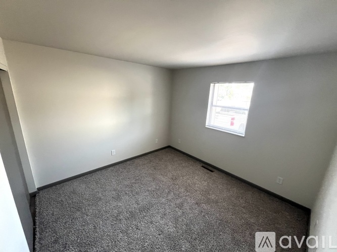 A room with a carpeted floor and a window.