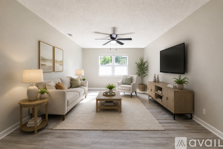 A living room with a white couch, a wooden coffee table, a flat screen TV, and a ceiling fan.
