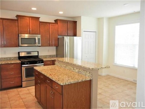 A kitchen with wooden cabinets and granite countertops.