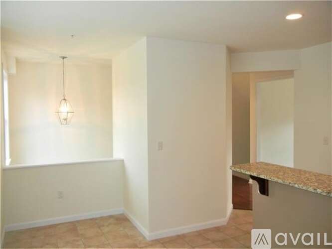 A room with a marble countertop and a hanging light fixture.