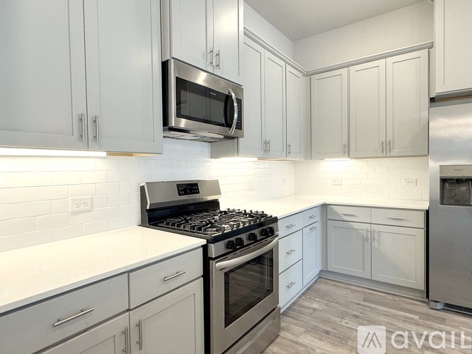 A kitchen with white cabinets and a stainless steel stove.