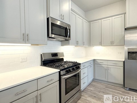 A kitchen with white cabinets and a stainless steel stove.