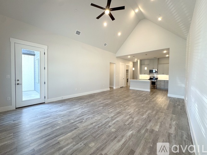 A spacious room with a ceiling fan and lighting fixtures.