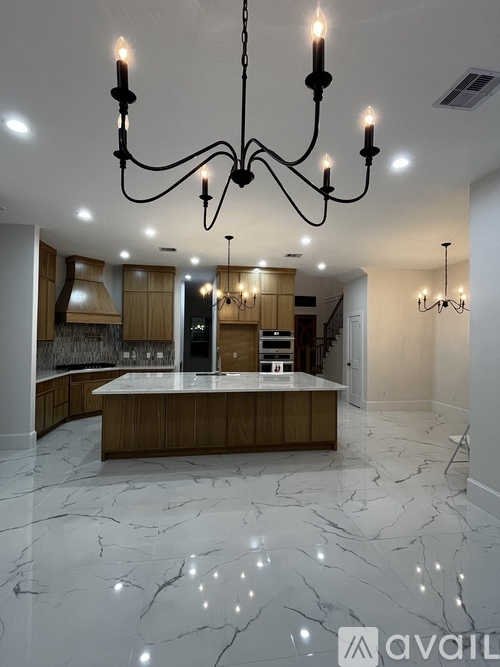 A modern kitchen with a marble floor and a large island.