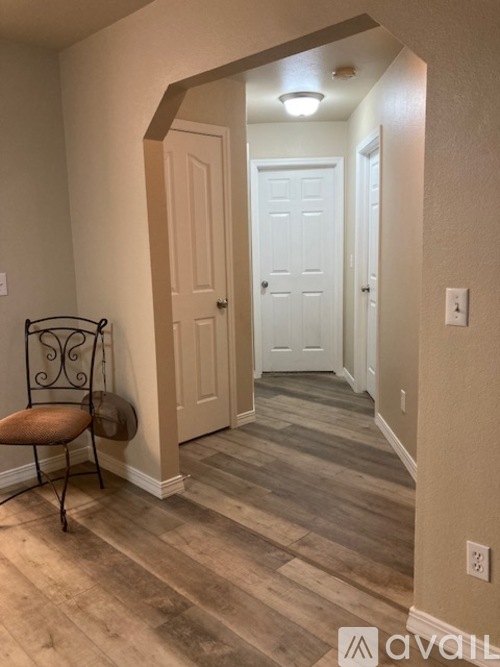 A hallway with a chair and a door.