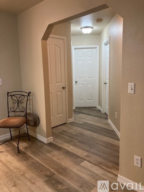 A hallway with a chair and a door.