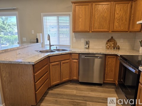 A kitchen with wooden cabinets and a marble countertop.