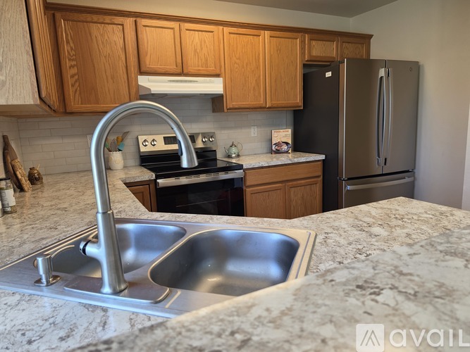 A kitchen with a sink, stove, and refrigerator.