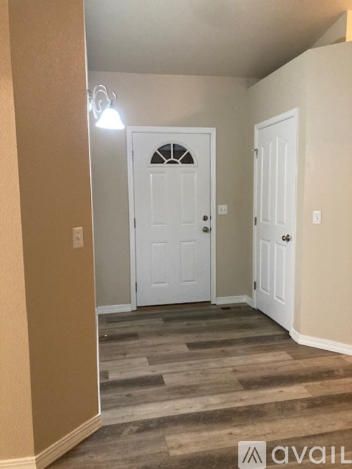 A hallway with a white door and a carpeted floor.
