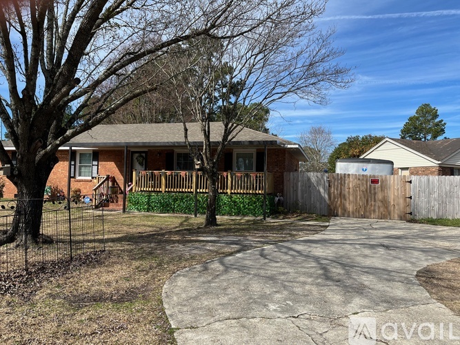 A house with a brown roof and a fence in front of it.