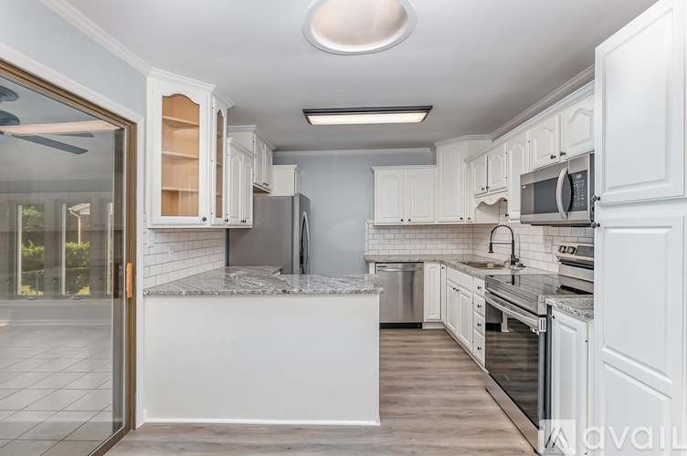 A modern kitchen with white cabinets and stainless steel appliances.
