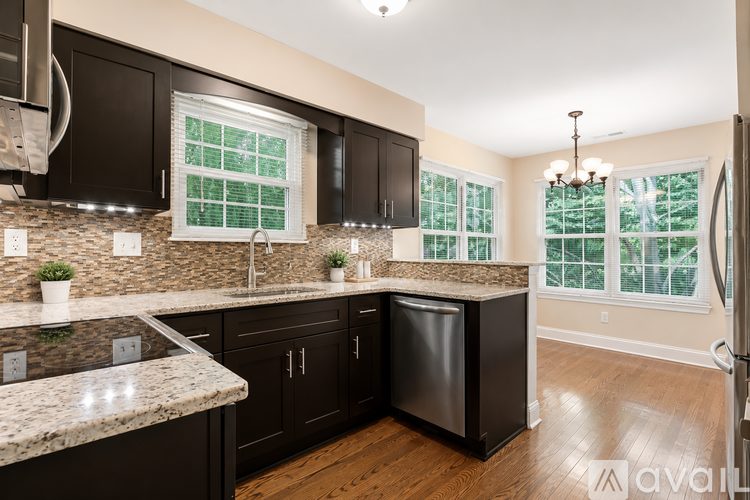 A kitchen with black cabinets and granite countertops.
