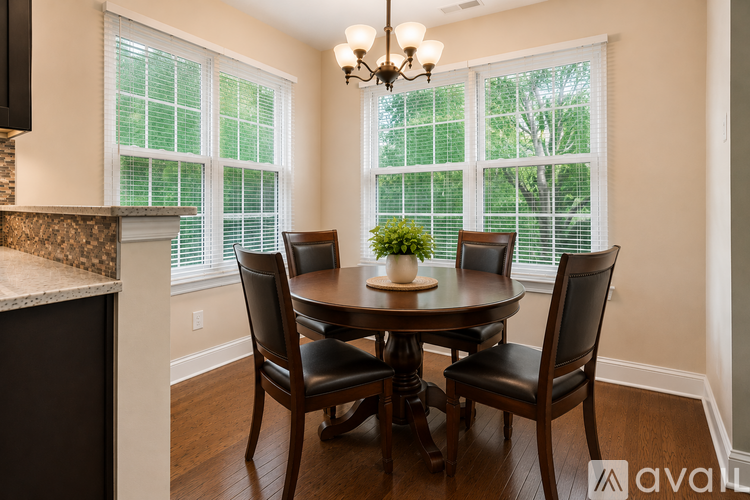 A dining room with a table and chairs.