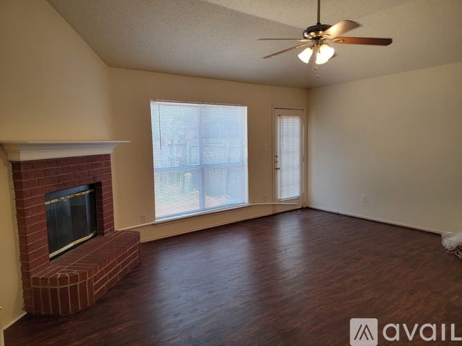 A living room with a fireplace and a ceiling fan.
