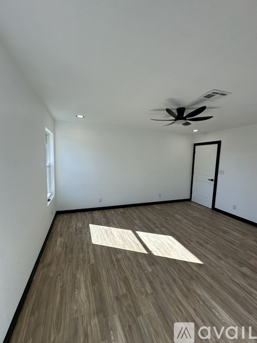 A room with wooden flooring and a ceiling fan.