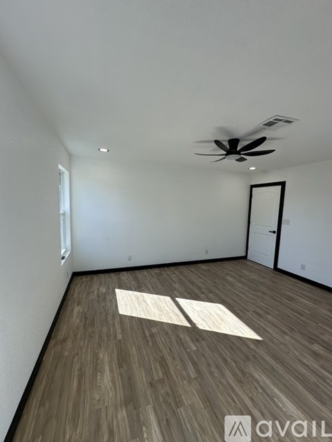 A room with wooden flooring and a ceiling fan.