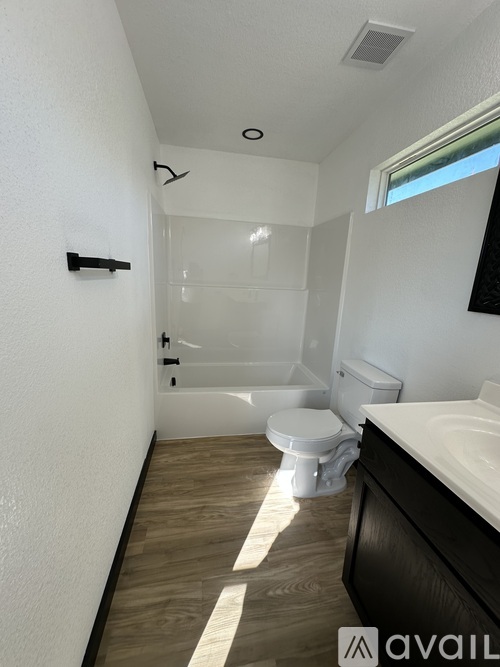 A bathroom with a toilet, sink, and bathtub.