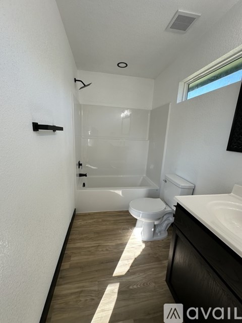 A bathroom with a toilet, sink, and bathtub.