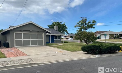A house with a blue door and a grey roof is for sale.