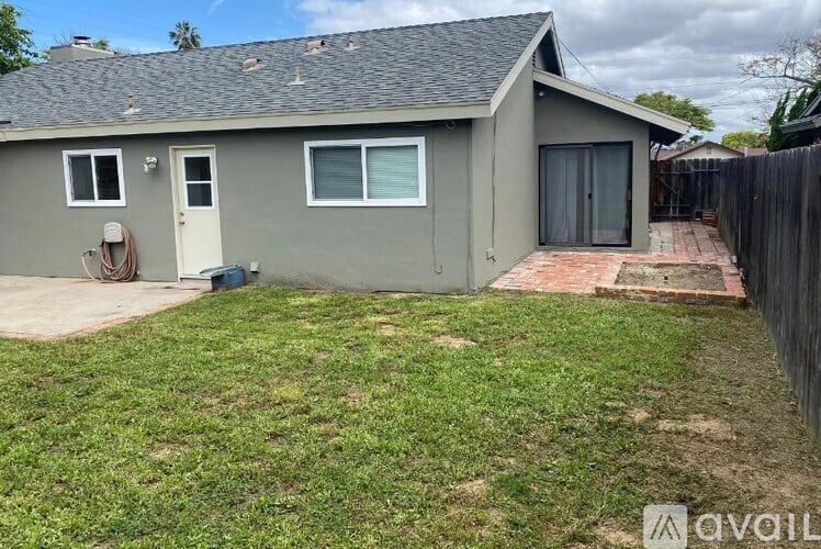 A house with a grey exterior and a small yard.