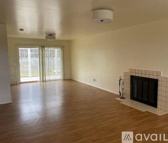 A living room with a fireplace and wooden floors.