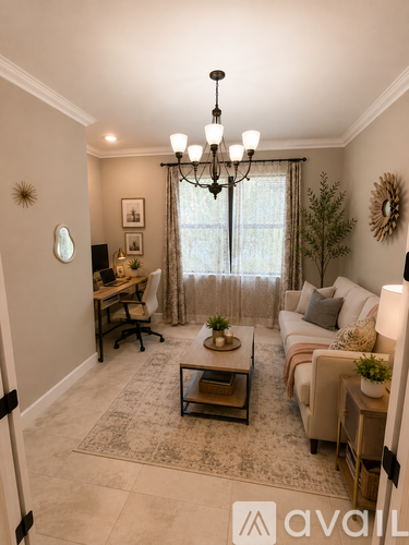 A living room with a couch, coffee table, and a chandelier.