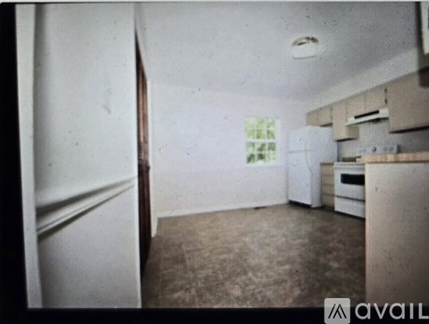 A kitchen area with a refrigerator, microwave, and cabinets.