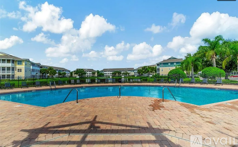 A large outdoor swimming pool surrounded by a brick patio.