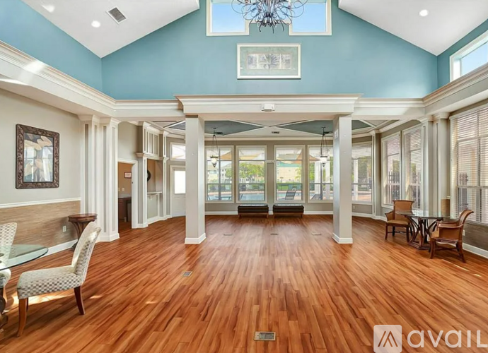 A spacious living room with hardwood floors and a high ceiling.