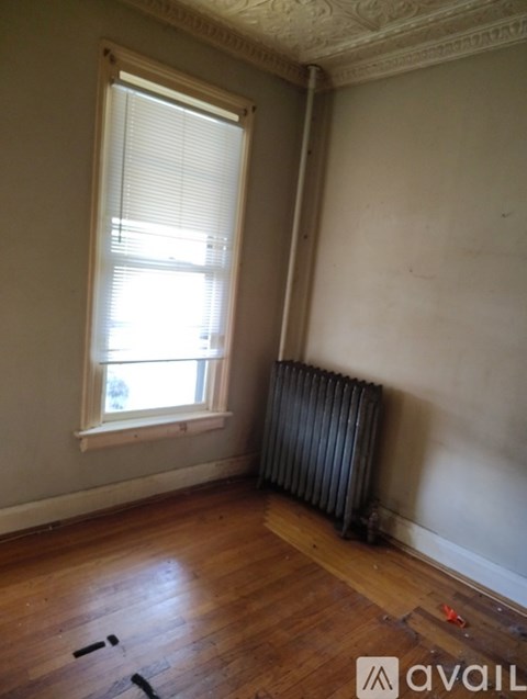 A room with a window and a radiator on the wall.